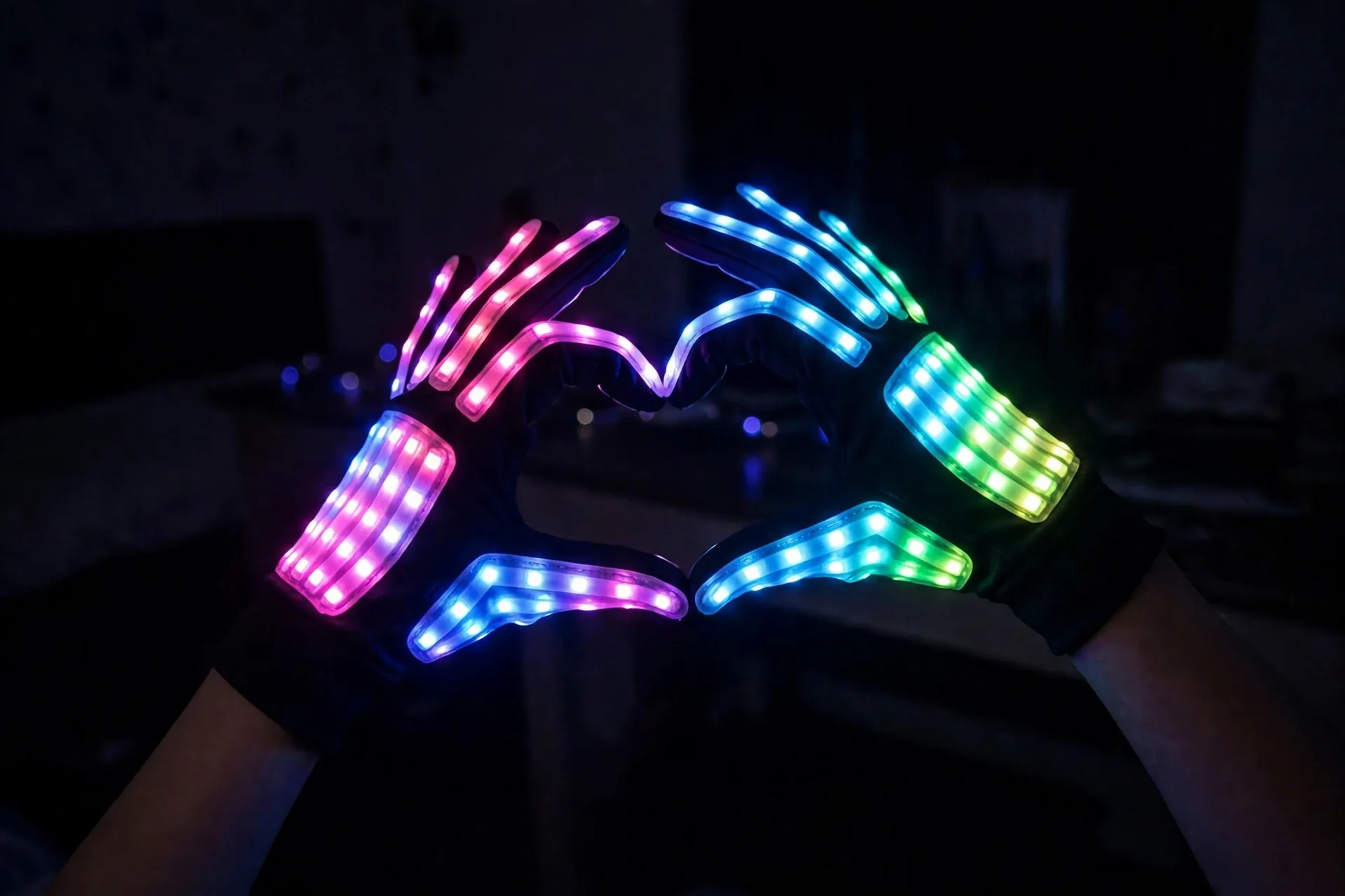 LED light-up gloves glowing in bright colors in a dark room
